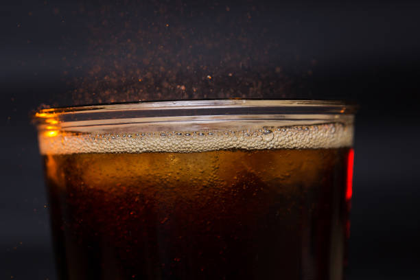istock Cola glass with ice cubes and droplets, isolated on black background 835994522