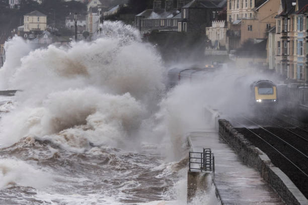 Intercity train getting a soaking from large waves just past Dawlish station in Devon UK