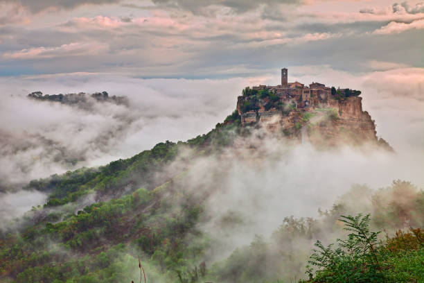 Civita di Bagnoregio, Viterbo, Lazio, Italy: landscape at dawn with fog stock photo