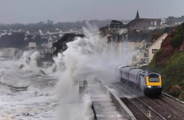 Photo of Intercity train leaving Dawlish station and getting a soaking from storm waves