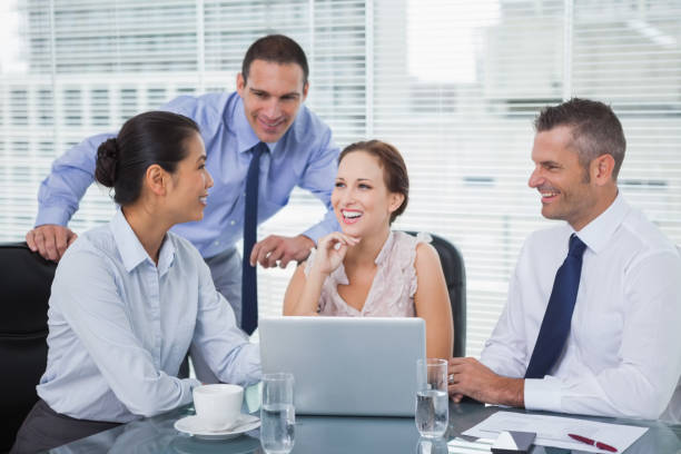 istock Cheerful colleagues around laptop working together 835998738