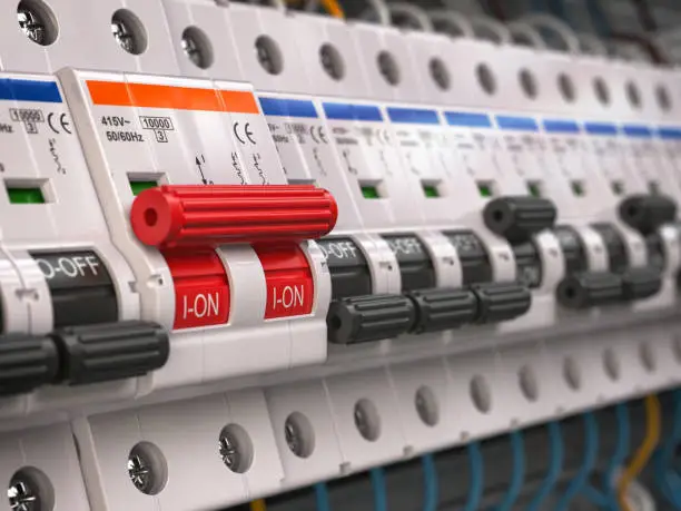 Photo of Switches in fusebox. Many black circuit brakers in a row in position OFF and one red switch in position ON.