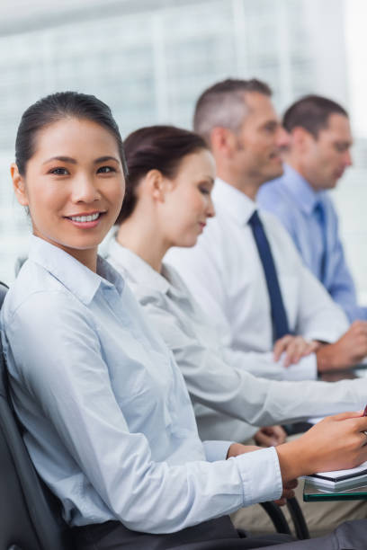 istock Cheerful employee attending presentation with her colleagues 835999260