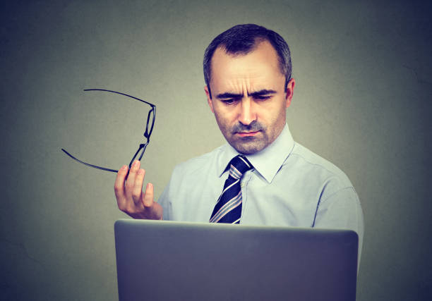 istock Confident man in shirt and tie looking at his laptop while sitting at his working place 836002324