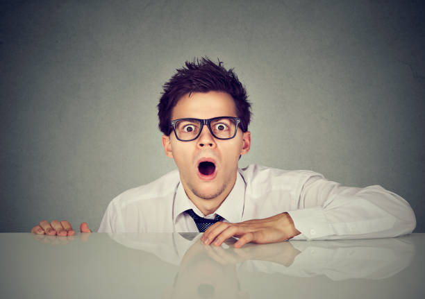 istock Shocked scared man coming out from under the table 836004444