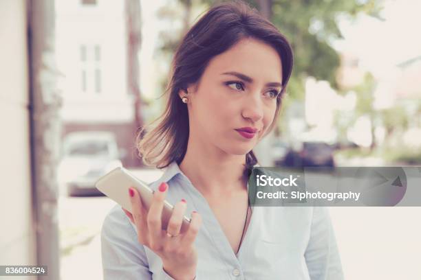 Frustrated Annoyed Sad Woman With Mobile Phone Standing Outside In The Street With An Urban Background Stock Photo - Download Image Now