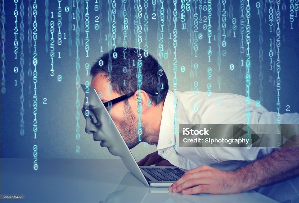 Profil de côté d’un homme d’affaires jeune avec son visage en passant par l’écran d’un ordinateur portable sur fond de code binaire - Photo de Comportement addictif libre de droits