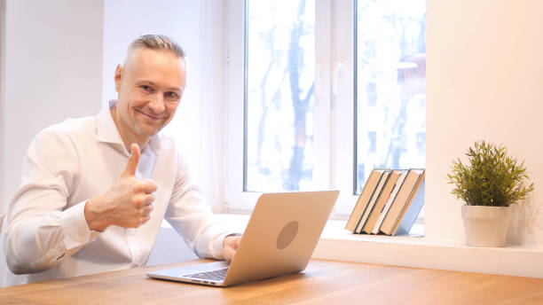 istock Thumbs Up by Middle Age Man while Working on Laptop 836020288