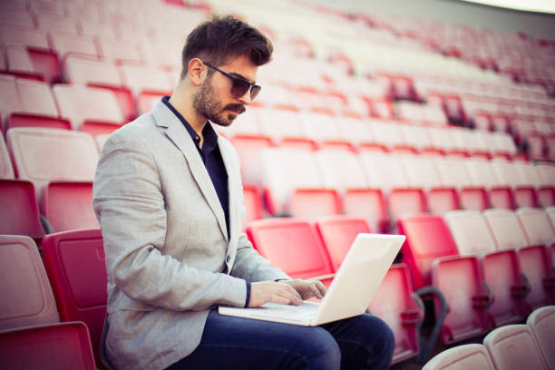 istock Young businessman watching game and using laptop 836030670
