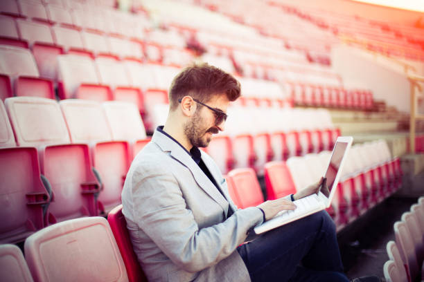 istock Young businessman watching game and using laptop 836030738