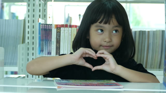 Asian girl in library , Heart Sign