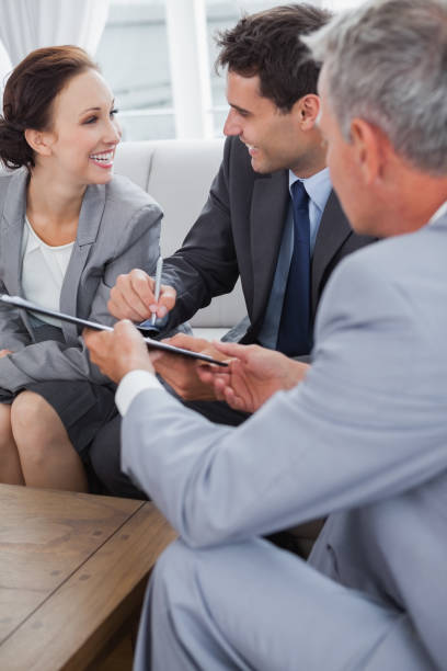 istock Businessman signing contract while looking at his partner 836040232