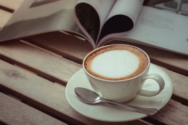 istock Cup of coffee and book on wooden table 836044378