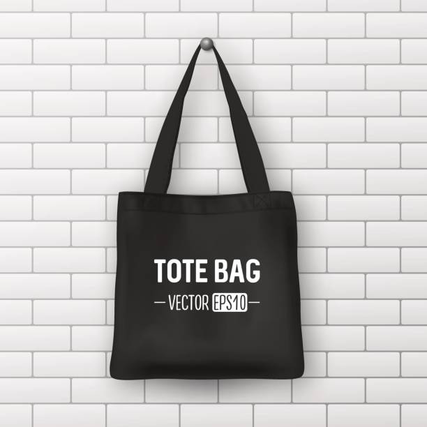 Realistic vector black textile tote bag. Closeup on brick wall background. Design template for branding, mockup. EPS10 Realistic vector black textile tote bag. Closeup on brick wall background. Design template for branding, mockup. EPS10 illustration. tote bag mock up stock illustrations