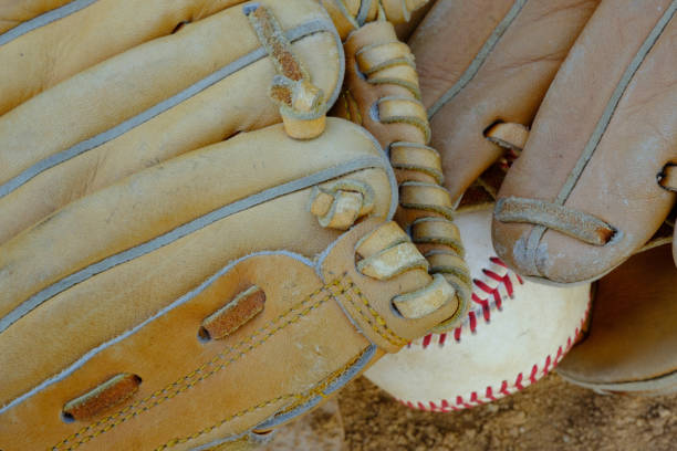 istock Well used baseball and a glove in a baseball field 836044554