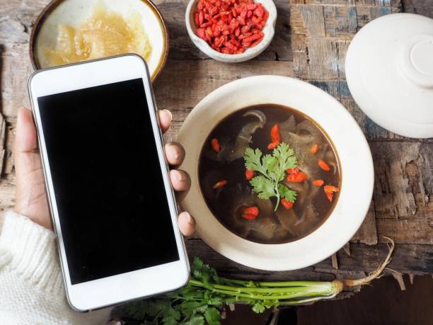 istock Smart phone on hand with chinese soup with shark fin 836051914