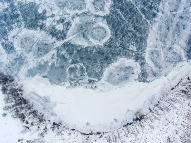 aerial top down view over icy lake surface pattern, near latazeris village. winter season in lithuania. - coastline aerial view forest pond imagens e fotografias de stock