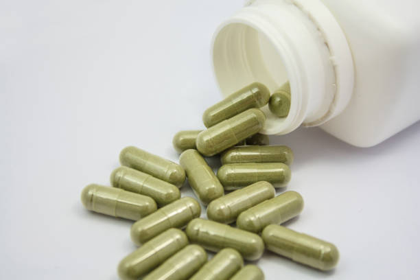 istock herbal capsules spilling out of a bottle 836059276
