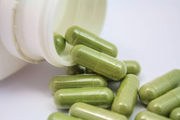istock herbal capsules spilling out of a bottle 836059320