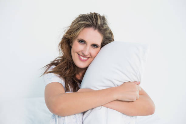 istock Smiling woman embracing pillow 836069010