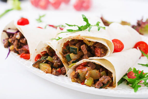 istock Burritos wraps with beef and vegetables on a light  background. 836077064