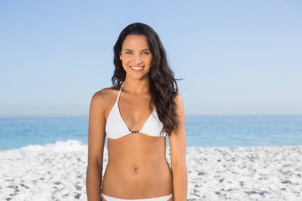 istock Smiling pretty long haired woman in white bikini posing 836084364