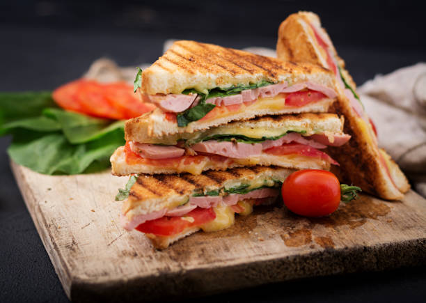 istock Club sandwich panini with ham, tomato, cheese and basil. 836087758