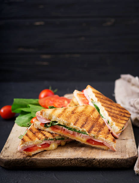 istock Club sandwich panini with ham, tomato, cheese and basil. 836087774