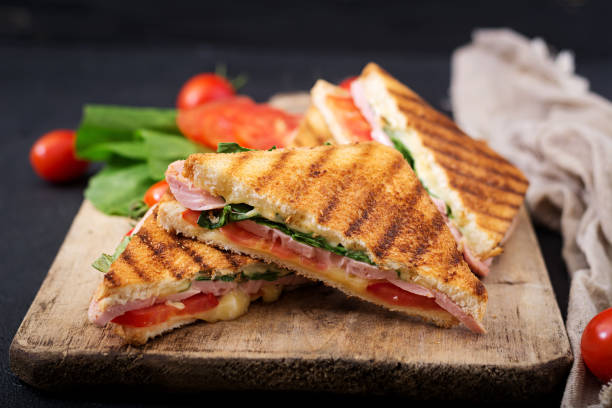 istock Club sandwich panini with ham, tomato, cheese and basil. 836087778