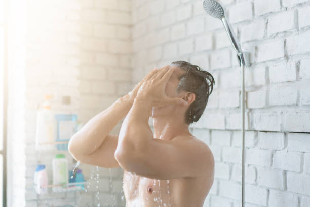 hommes asiatiques prennent une douche dans la salle de bain, il est heureux et détendu. - men naked water male photos et images de collection