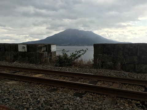 railroad with Sakurajima Volcano in background in Kagoshima Kyushu island Japan