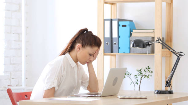 istock Woman  Upset by Loss, Working on Laptop 836098926