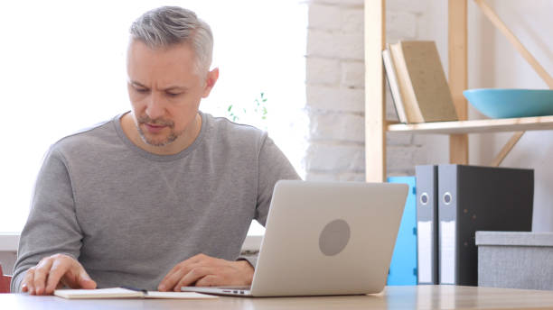 istock Middle Aged Man Reading at Work in His Office 836102250