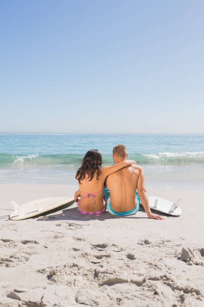 istock Beautiful young couple sitting with their surfboards 836102864