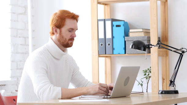 istock Man with Red Hairs Typing On Laptop in Office 836105320
