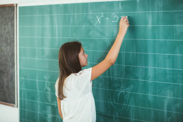 istock Happy schoolchild writing on blackboard 836112398