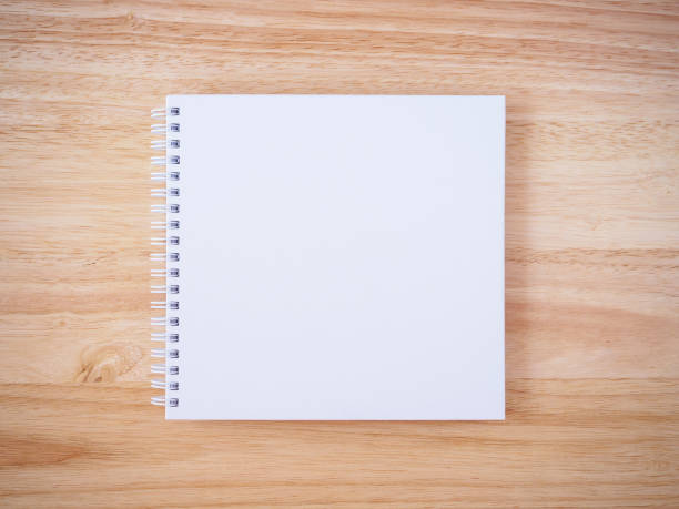 istock white cover notebook on brown wood desk background 836120246