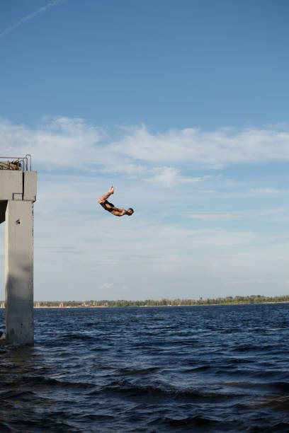 istock Man jumping into sea from pier 836125260