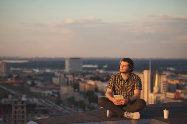 istock Man is listening to music on roof. 836125286