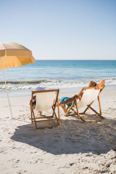 istock Happy couple sunbathing on their deck chairs 836125316