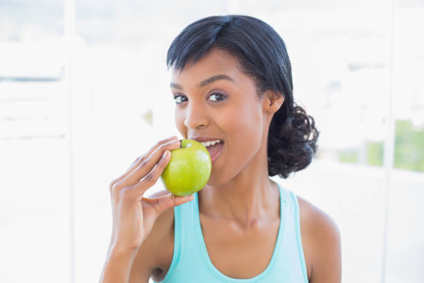 istock Calm black haired woman eating an apple 836139140