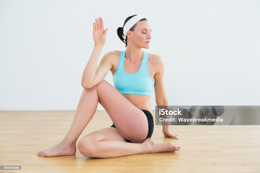 Woman doing the spine twisting pose at fitness studio Full length of a fit young woman doing the spine twisting pose at fitness studio 20-29 Years Stock Photo