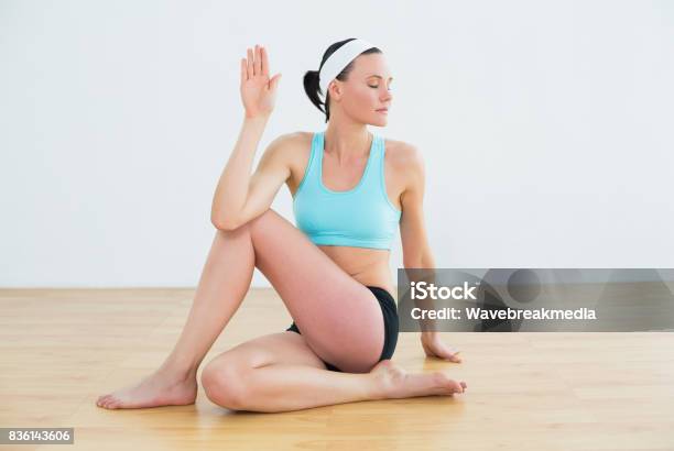 Woman Doing The Spine Twisting Pose At Fitness Studio Stock Photo - Download Image Now