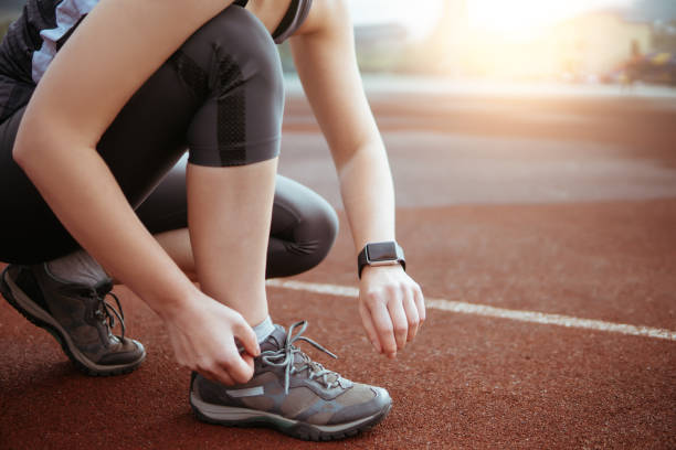 istock Female runner tying shoe lace in a stadium area. 836146550