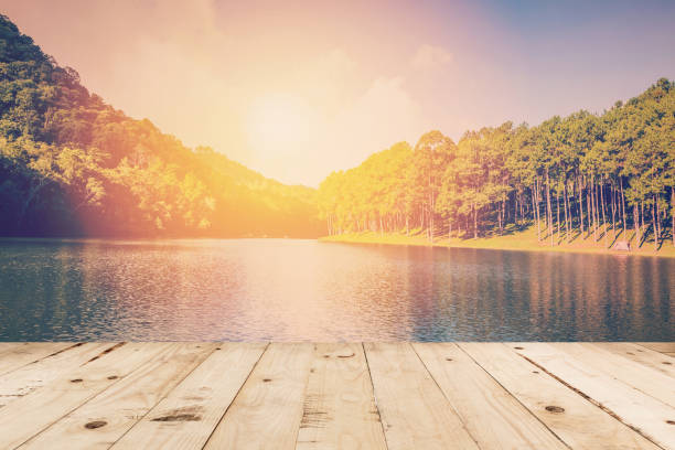 istock Wood table and Pond water and sunrise with vintage effect. 836146678