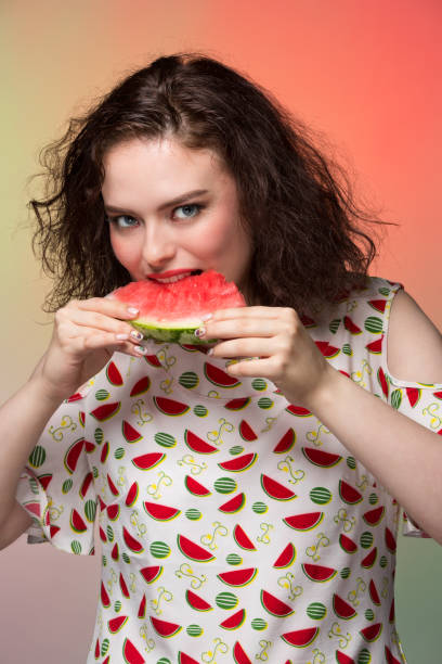 istock Girl with makeup holds a watermelon slice and eats it 836150442