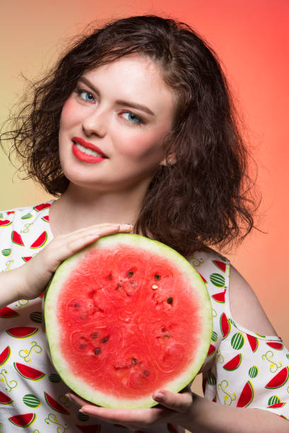 istock Girl with makeup holds a cut watermelon 836150444