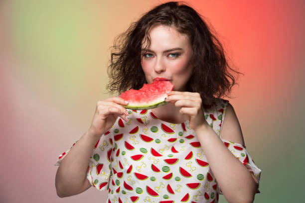 istock Girl with makeup holds a watermelon slice and eats it 836150462