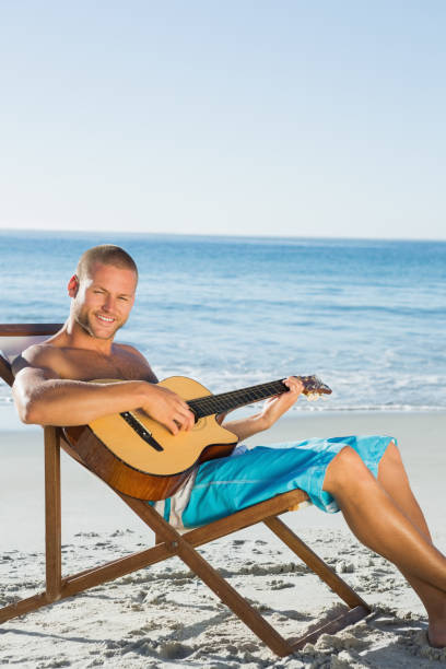 istock Cheerful handsome man strumming guitar 836154650