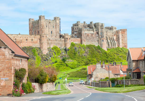 Bamburgh Village and Castle Bamburgh, United Kingdom - June 12, 2012: A view of the picturesque village of Bamburgh, in Northumberland in England, with Bamburgh Castle in the background. Bamburgh stock pictures, royalty-free photos & images